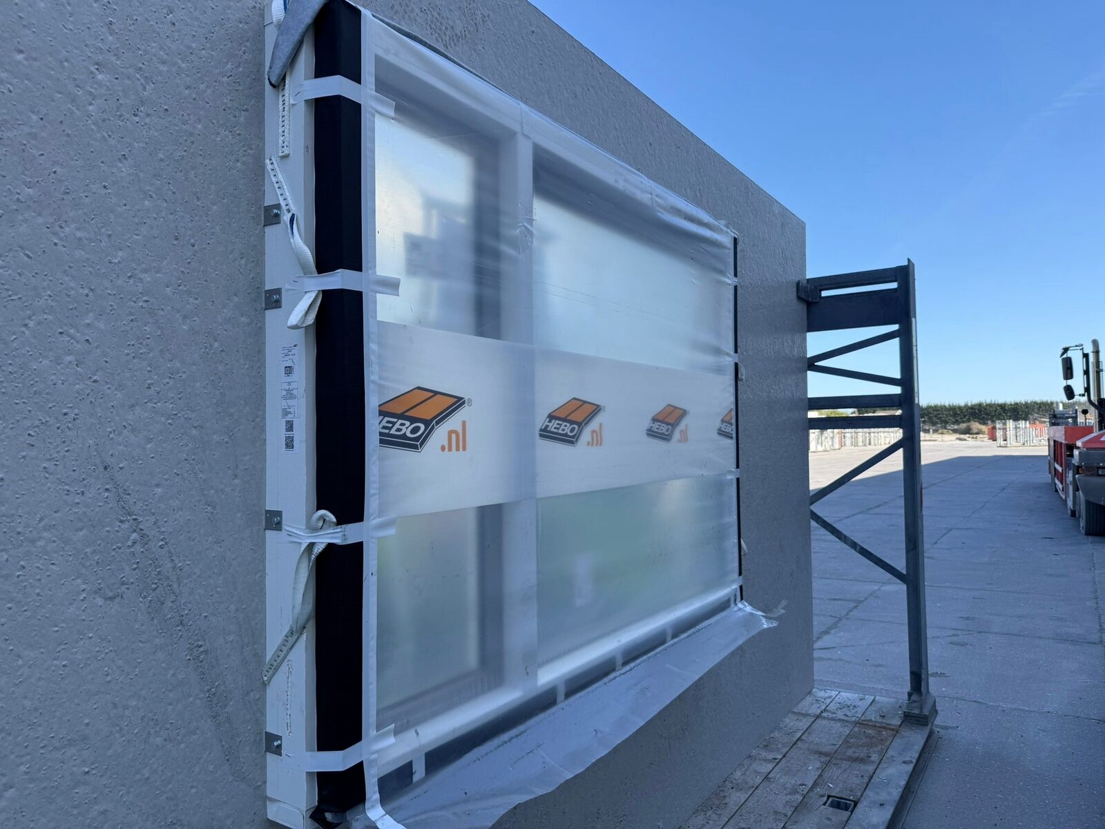 Ein vollständig verglastes und geschütztes, vorgefertigtes Fensterrahmenelement, bereit für den Transport und die Montage.